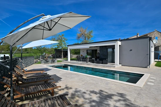 Maison contemporaine avec extension moderne située sur terrain paysager avec pelouse verte
