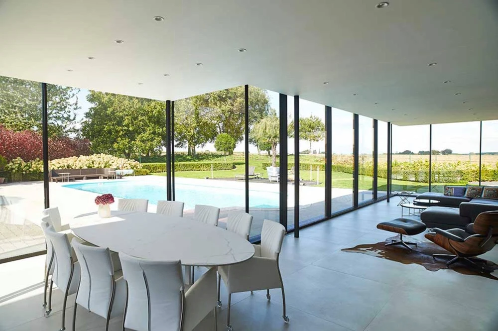 Terrasse extérieure moderne avec pergola bioclimatique à lames orientables en aluminium anthracite, fixée en appui sur façade