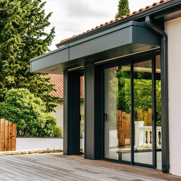 Extension vitrée moderne accolée à une maison en pierre de taille ancienne