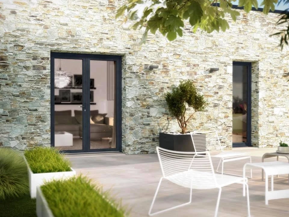 Façade de maison en enduit beige avec encadrement en pierre de taille