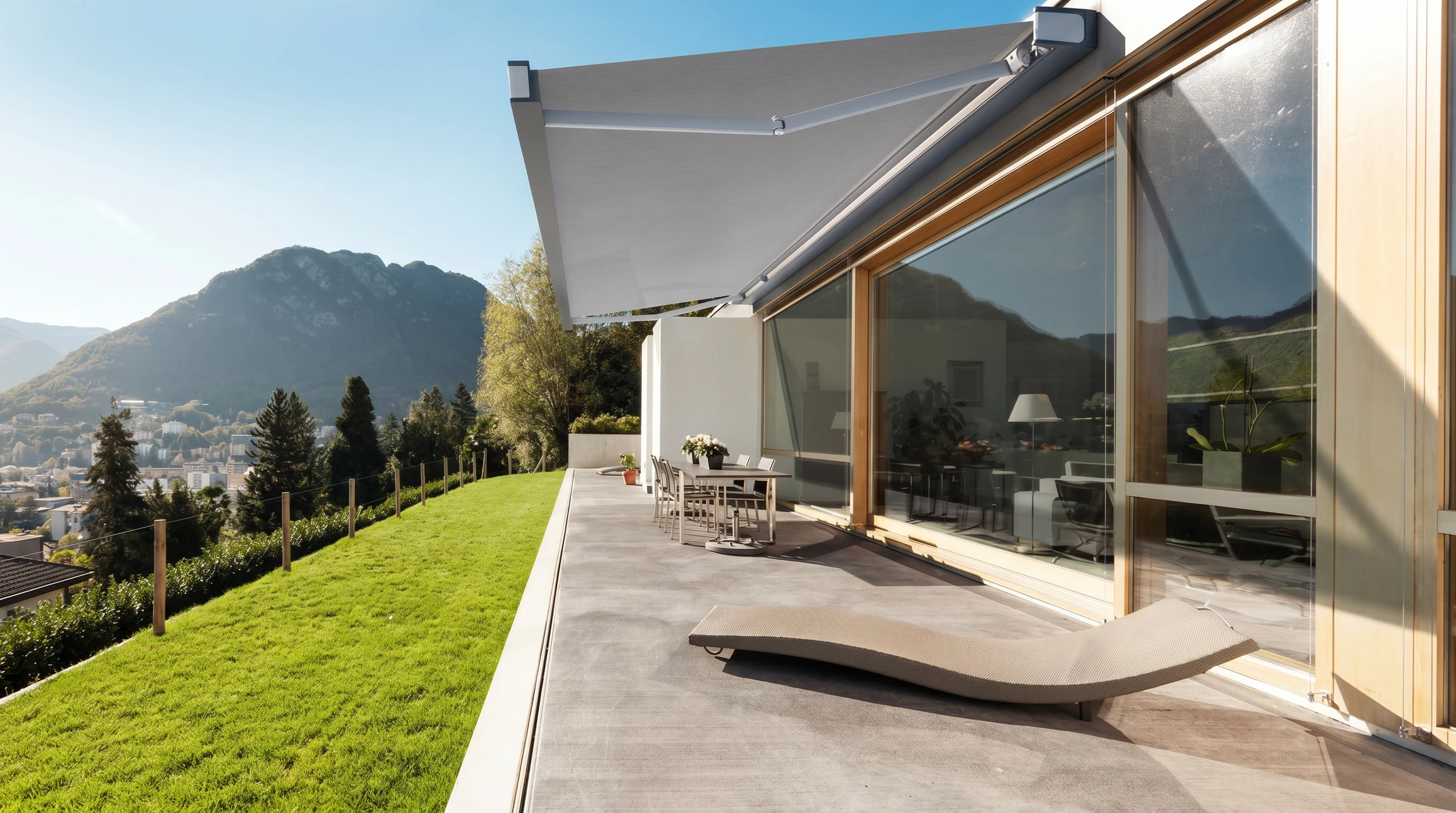 Façade d'une maison résidentielle dotée de stores extérieurs ou d'une pergola bioclimatique moderne installés sur une terrasse ou une fenêtre, photographiée en lumière naturelle. La scène montre clairement les protections solaires en position fonctionnelle (stores demi-fermés permettant de filtrer la lumière tout en conservant une visibilité vers l'extérieur), avec un rendu professionnel et une qualité de photographie immobilière.