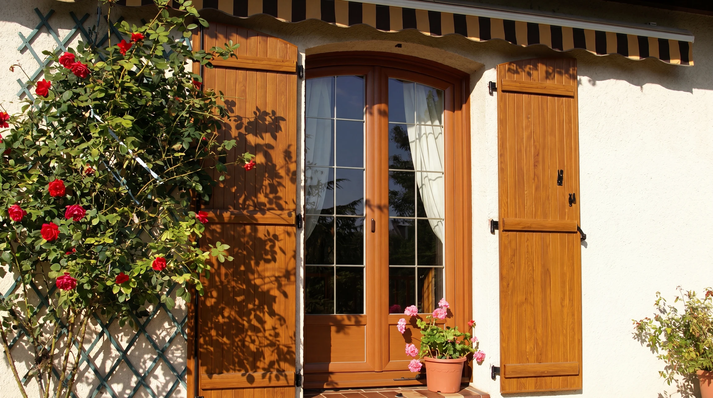 Façade de maison moderne avec volets roulants électriques gris anthracite en position fermée