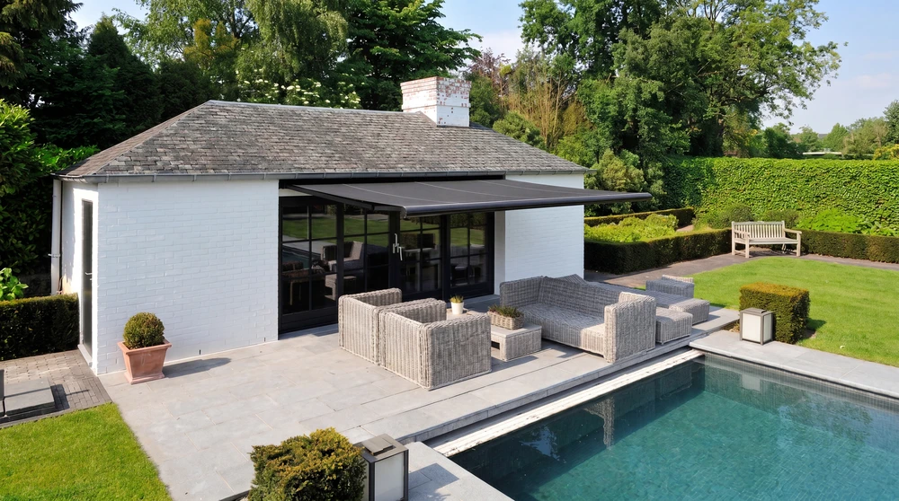 Terrasse extérieure moderne avec pergola bioclimatique à lames orientables en aluminium anthracite, fixée en appui sur façade
