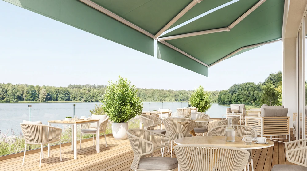 Terrasse extérieure moderne avec pergola bioclimatique à lames orientables en aluminium anthracite, fixée en appui sur façade