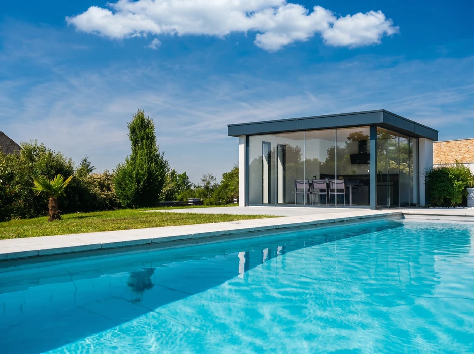 Pool house moderne à toiture plate, bardage bois brûlé (shou sugi ban) noir, avec façade centrale en teck naturel