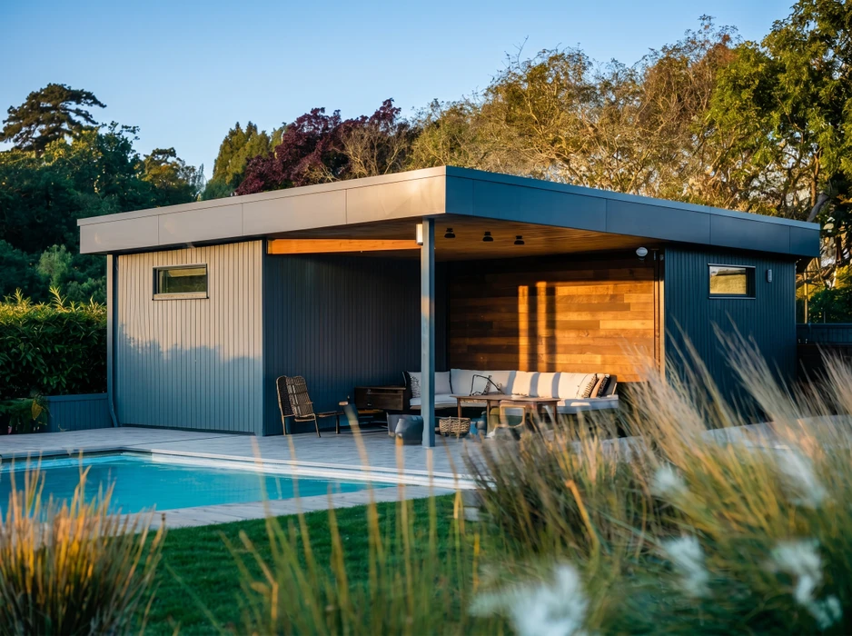 Véranda moderne adossée à une maison à façade orangée, avec terrasse en bois composite