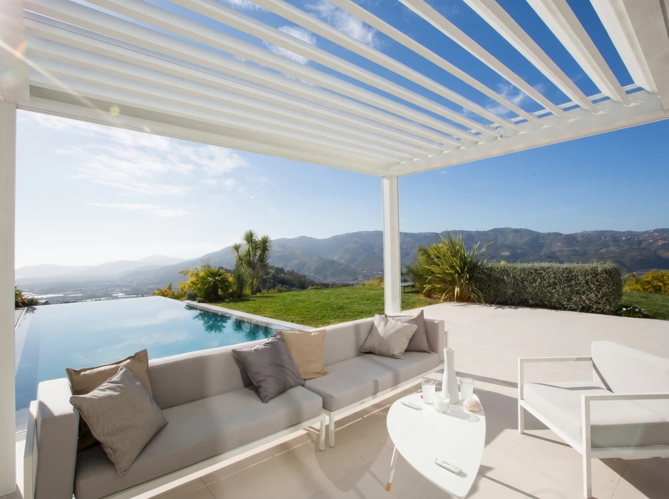 Terrasse couverte moderne avec pergola bioclimatique, plafond en lambris bois naturel avec spots encastrés, structure en aluminium anthracite