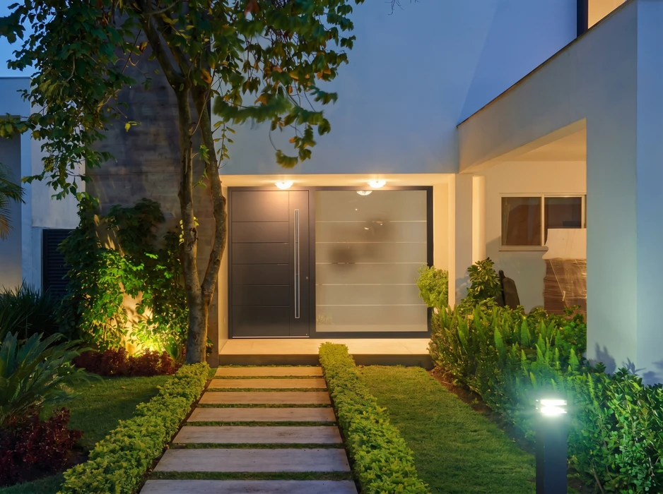 Véranda moderne adossée à une maison à façade orangée, avec terrasse en bois composite