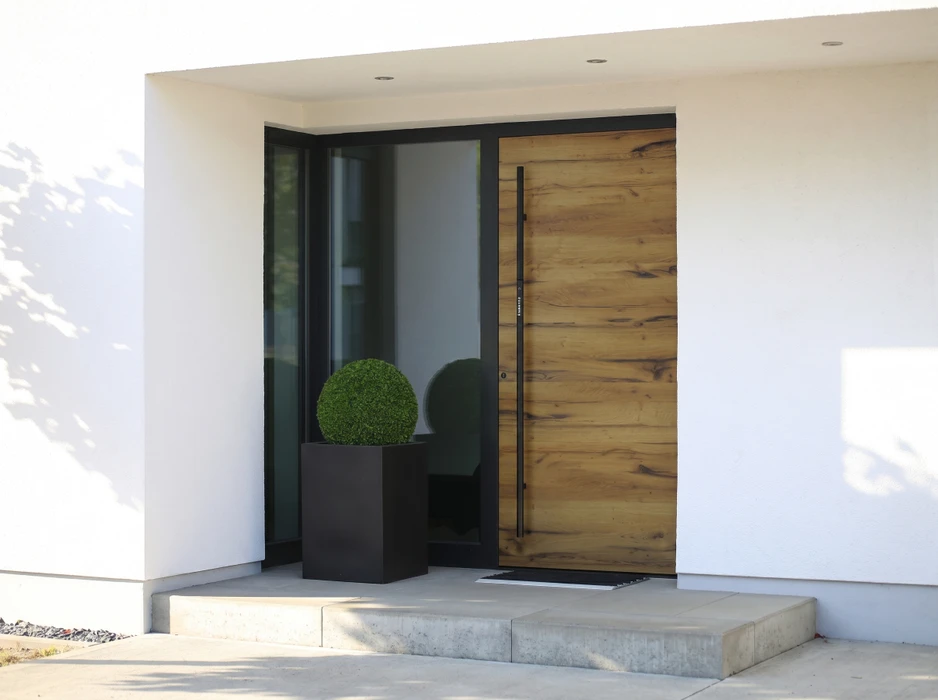 Véranda moderne adossée à une maison à façade orangée, avec terrasse en bois composite