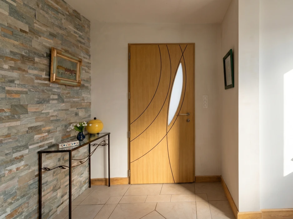 Véranda moderne adossée à une maison à façade orangée, avec terrasse en bois composite