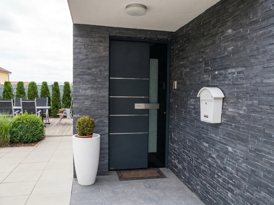 Véranda moderne adossée à une maison à façade orangée, avec terrasse en bois composite